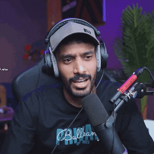 a man wearing headphones is singing into a microphone with the word bulkan on his shirt