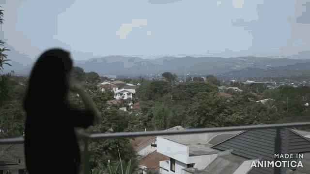 a woman is standing on a balcony overlooking a city with the words made in animotica on the bottom right