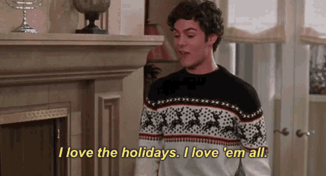 a man in a sweater says i love the holidays i love em all .
