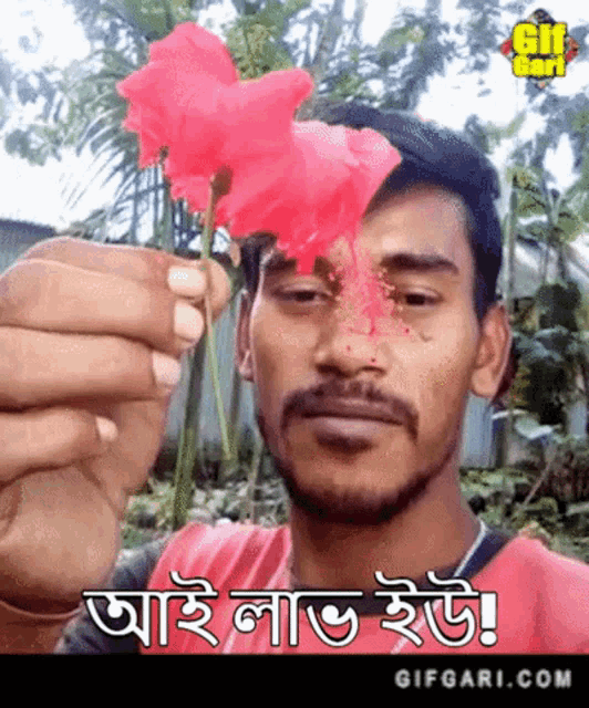 a man with a beard is holding a red flower in front of his face and says gifgari.com on the bottom