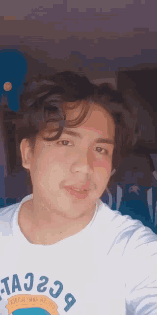 a young man taking a selfie with a white shirt that says ta229 on it