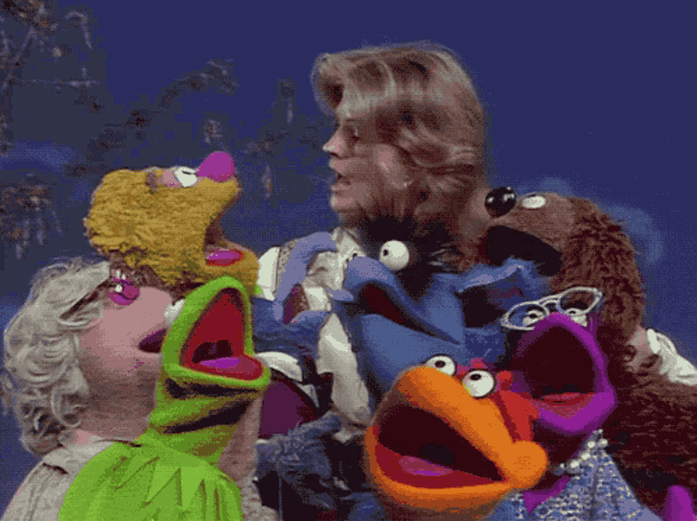 a woman is surrounded by stuffed animals including kermit the frog