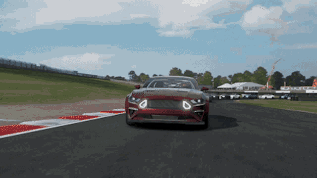 a red car is driving down a race track in a video game