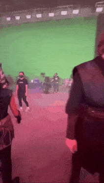 a group of people standing in a room with a green screen behind them