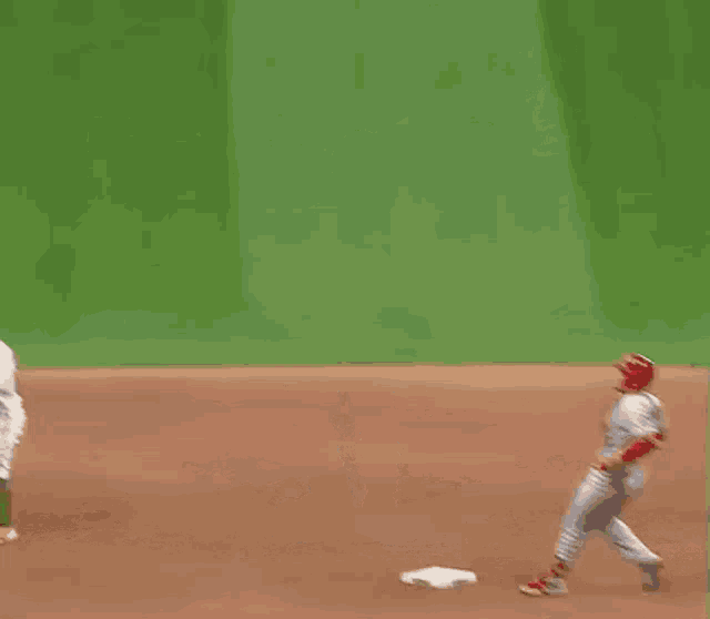 a baseball player is standing on a base on a field .