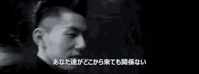 a black and white photo of a man with foreign writing on the bottom