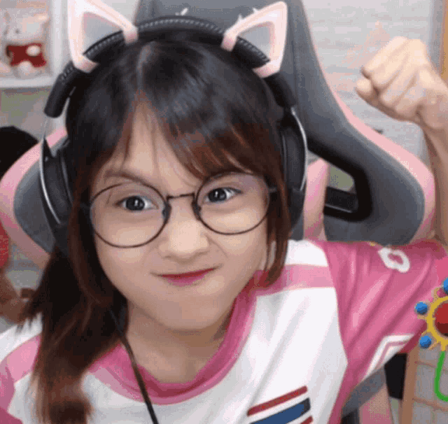 a young girl wearing glasses and headphones is making a funny face