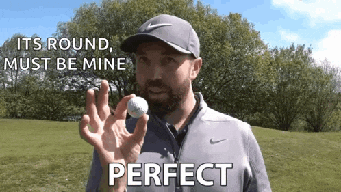 a man is holding a golf ball in his hand and saying `` its round , must be mine perfect '' .