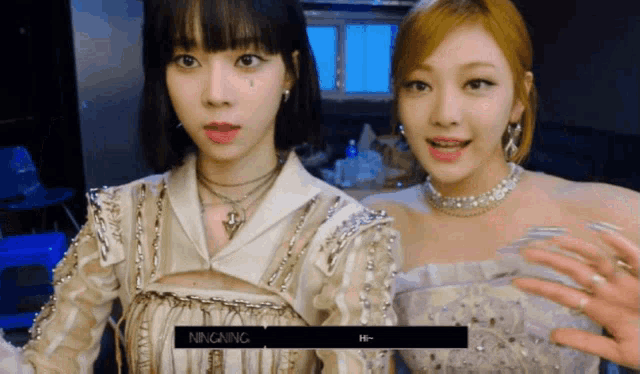 two girls are standing next to each other and one of them is wearing a necklace with the word ningning on it