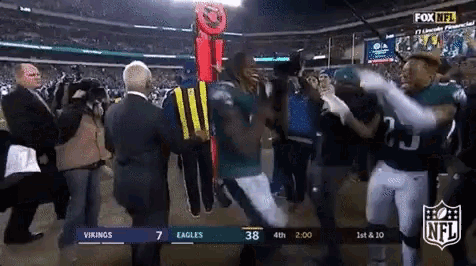 a group of football players are dancing in a stadium .
