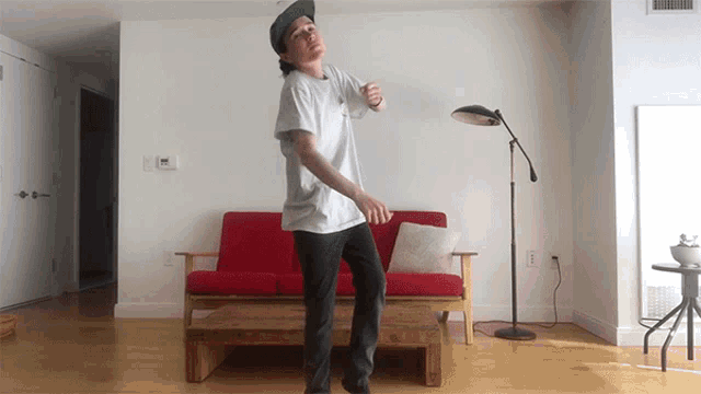 a man in a white shirt is dancing in a living room