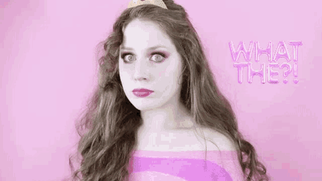 a woman with long hair and a tiara on her head is wearing a pink sweater and a pink top .
