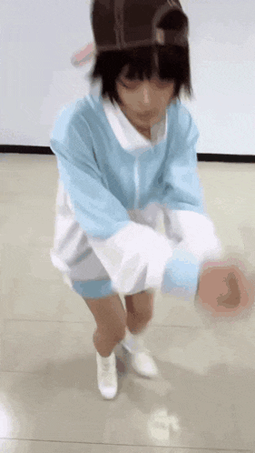 a person in a blue and white outfit is standing on a tiled floor