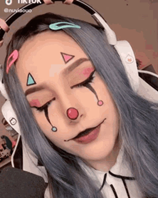 a girl with a clown face painted on her face