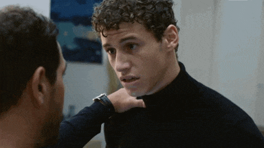 two men are looking at each other and one is wearing a watch