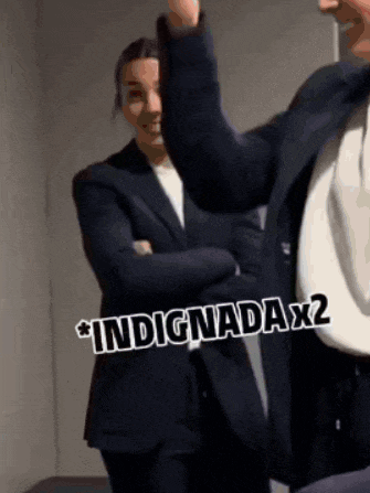 a man in a suit is standing next to a woman in a white shirt with the words indigadax2 on the bottom