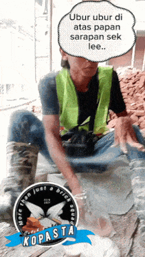 a man wearing a yellow vest sits in front of bricks