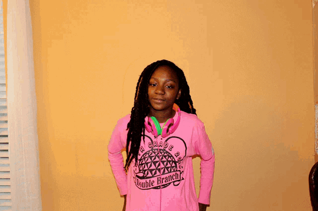 a girl wearing a pink shirt that says ' grade 2 ' on it