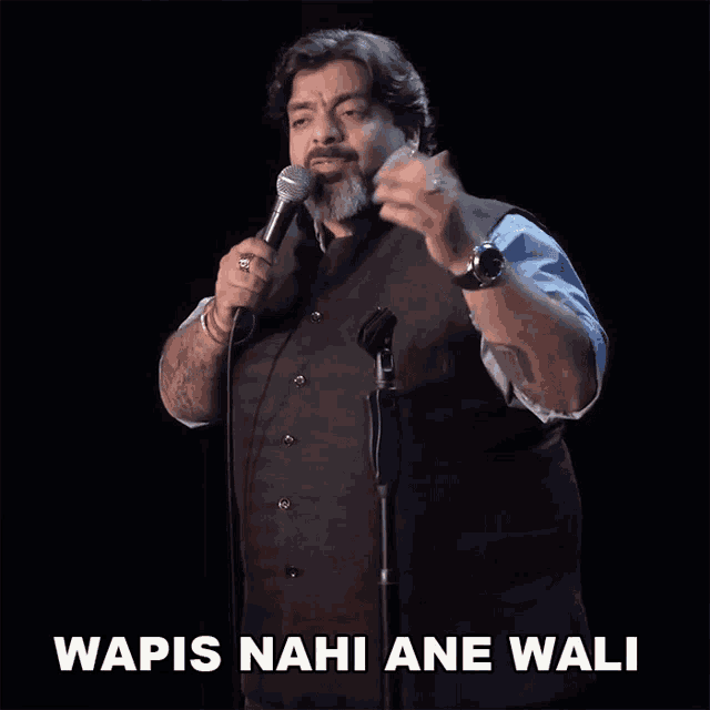 a man stands in front of a microphone with the words wapis nahi ane wali above him