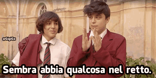 two boys are clapping in front of a building and the caption sembra abbia qualcosa nel retto