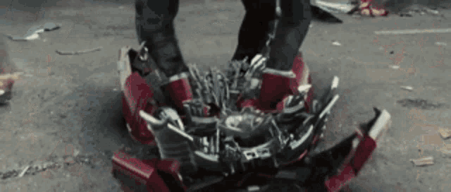 a person is standing on top of a broken robot .