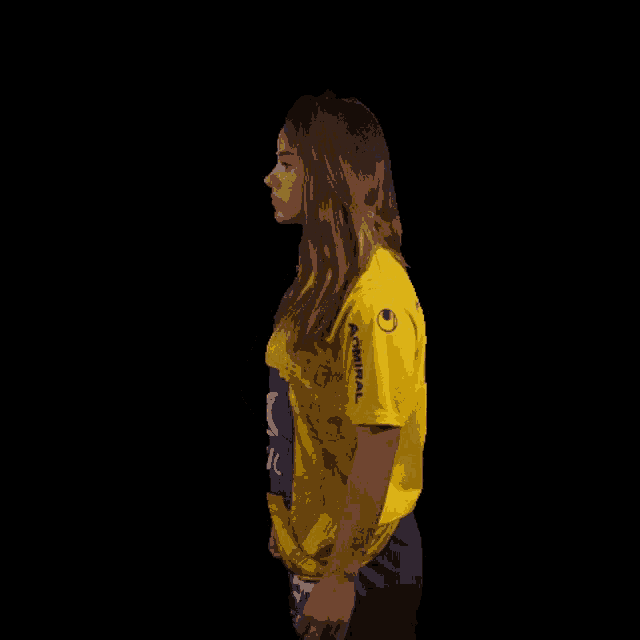 a woman in a yellow shirt that says arsenal on it