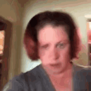 a blurry picture of a woman wearing headphones and a gray shirt .