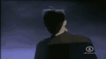 a man is standing in front of a vhs classic logo .