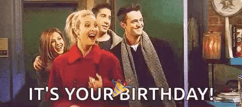 a group of people are standing next to each other and one of them is holding a birthday card .