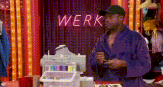 a man in a purple robe is standing in front of a sewing machine in a room .