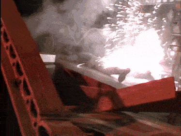 a person is laying in a red box with a fireball coming out of it