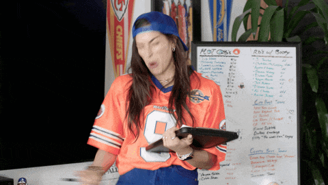 a woman standing in front of a white board that says hot dogs