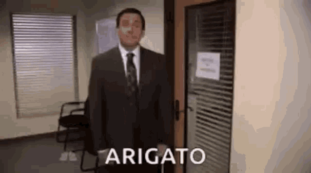 a man in a suit and tie is standing in front of a door in a waiting room .