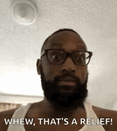 a man with glasses and a beard is wearing a white tank top and saying whew that 's a relief