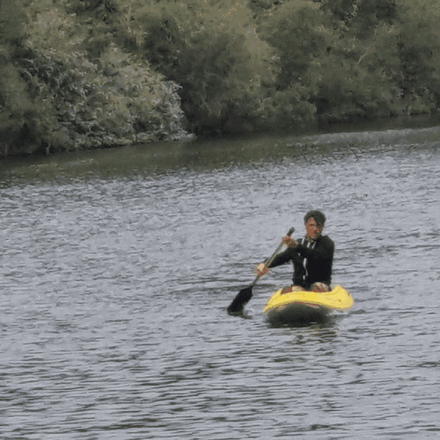 a man is paddling a yellow kayak in a river
