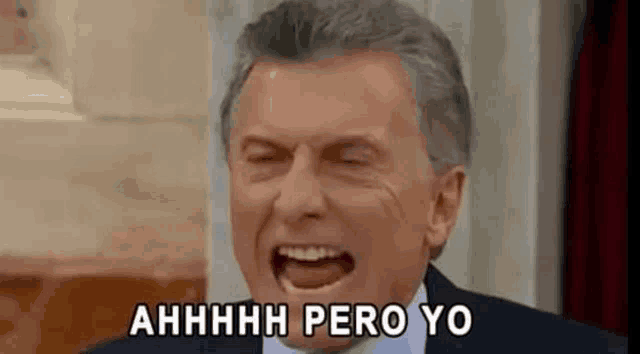 a man in a suit and tie is laughing with his mouth open and says ahhhh pero yo .