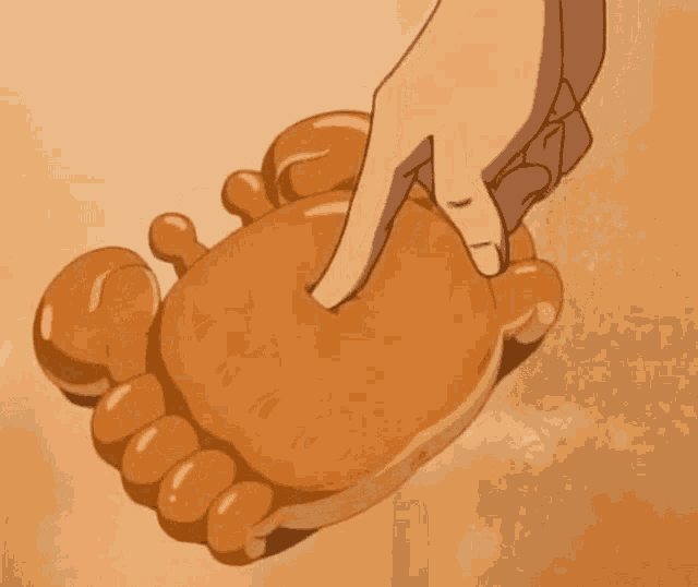 a person 's hand is touching a giant foot shaped object .