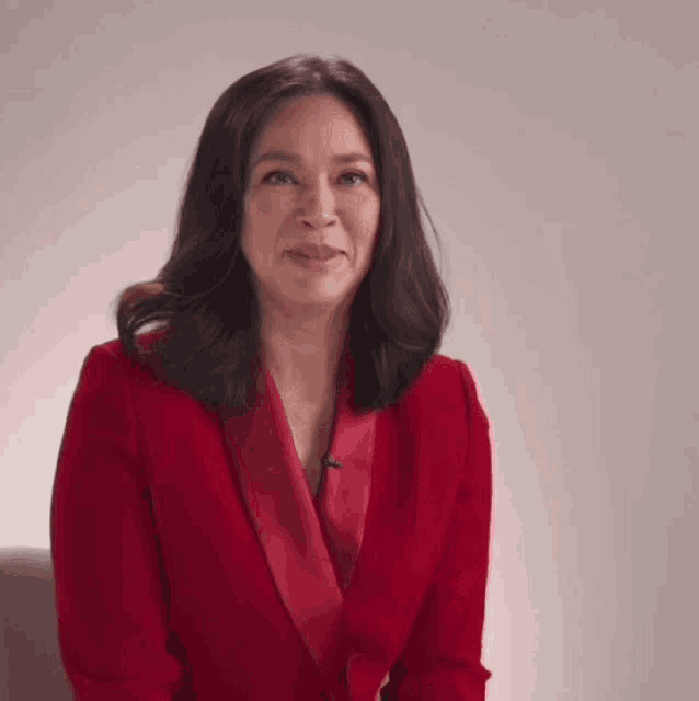 a woman in a red jacket is making a face .