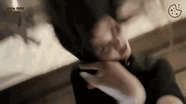 a woman is laying down with her head in the air while holding a cell phone .