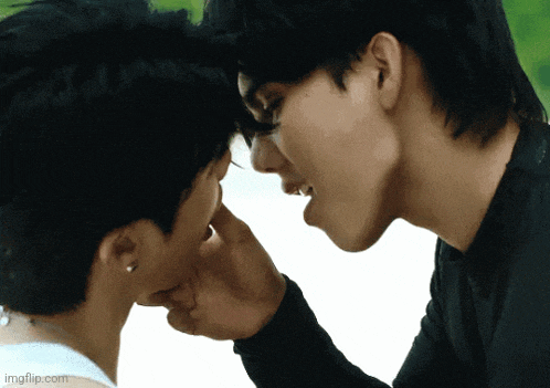 two men are touching each other 's faces and one of them is licking the other 's nose