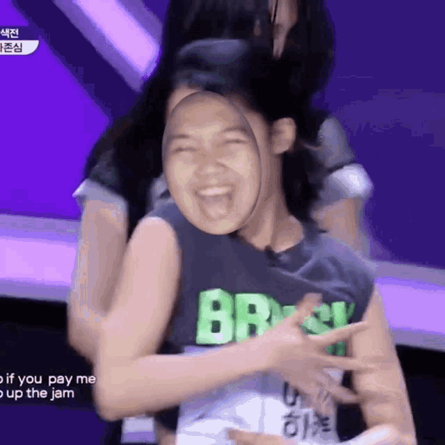 a girl wearing a shirt that says brasil is being hugged by another girl