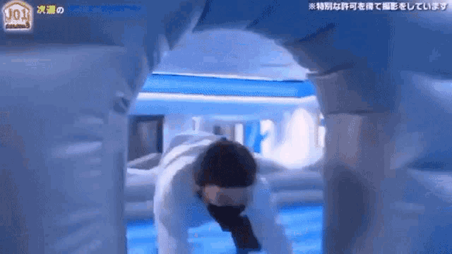 a man in a mask is crawling through a tunnel in a room .