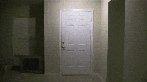a white door in a dark room with a light on it