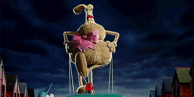 a stuffed bunny with a pink bow is sitting on top of a blue car