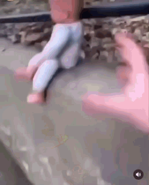 a person 's hand is reaching out towards a child 's feet .