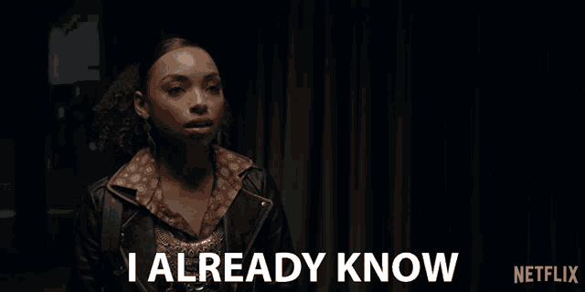 a woman says i already know in front of a curtain