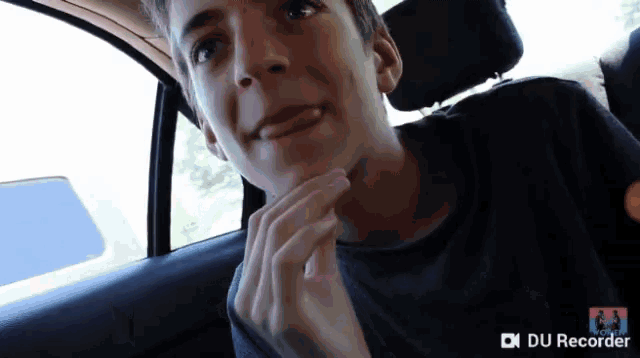 a young man sitting in a car with a du recorder watermark