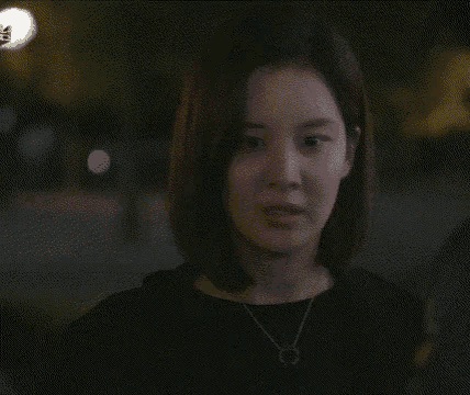 a woman is saying `` i 'm fine '' while standing in the dark .