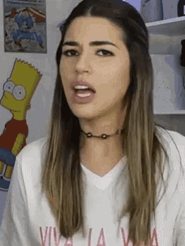 a woman wearing a bart simpson t-shirt making a funny face