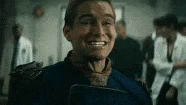 a man in a superhero costume is smiling in front of a group of people